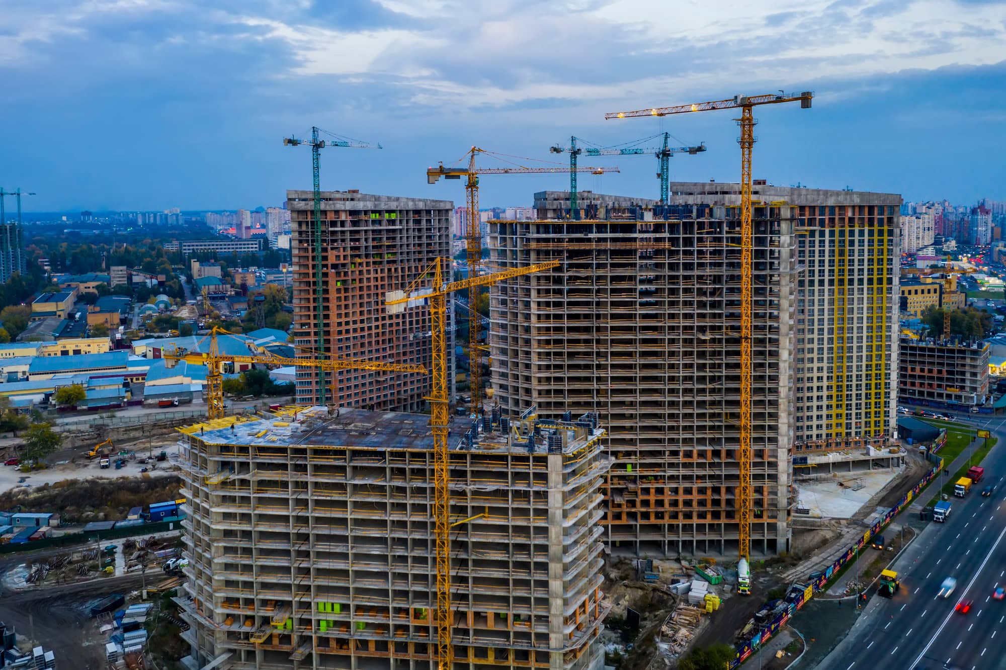 construction site with cranes at sunset construction of an apartment building